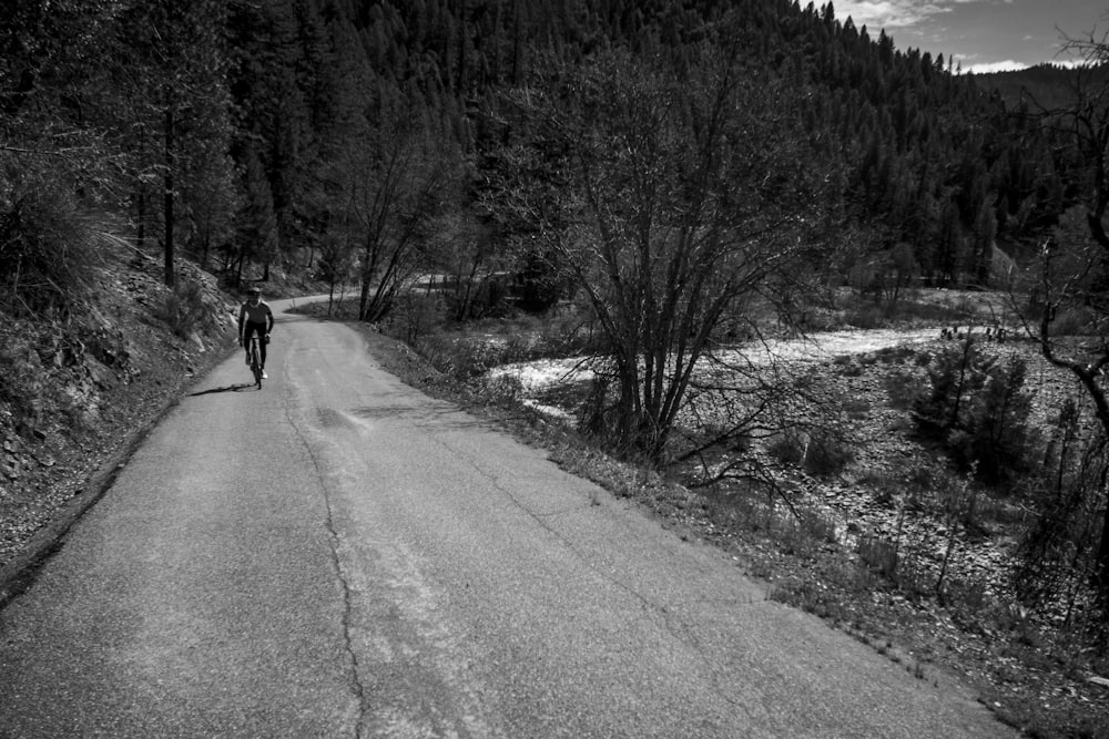 a black and white photo of a person walking down a road