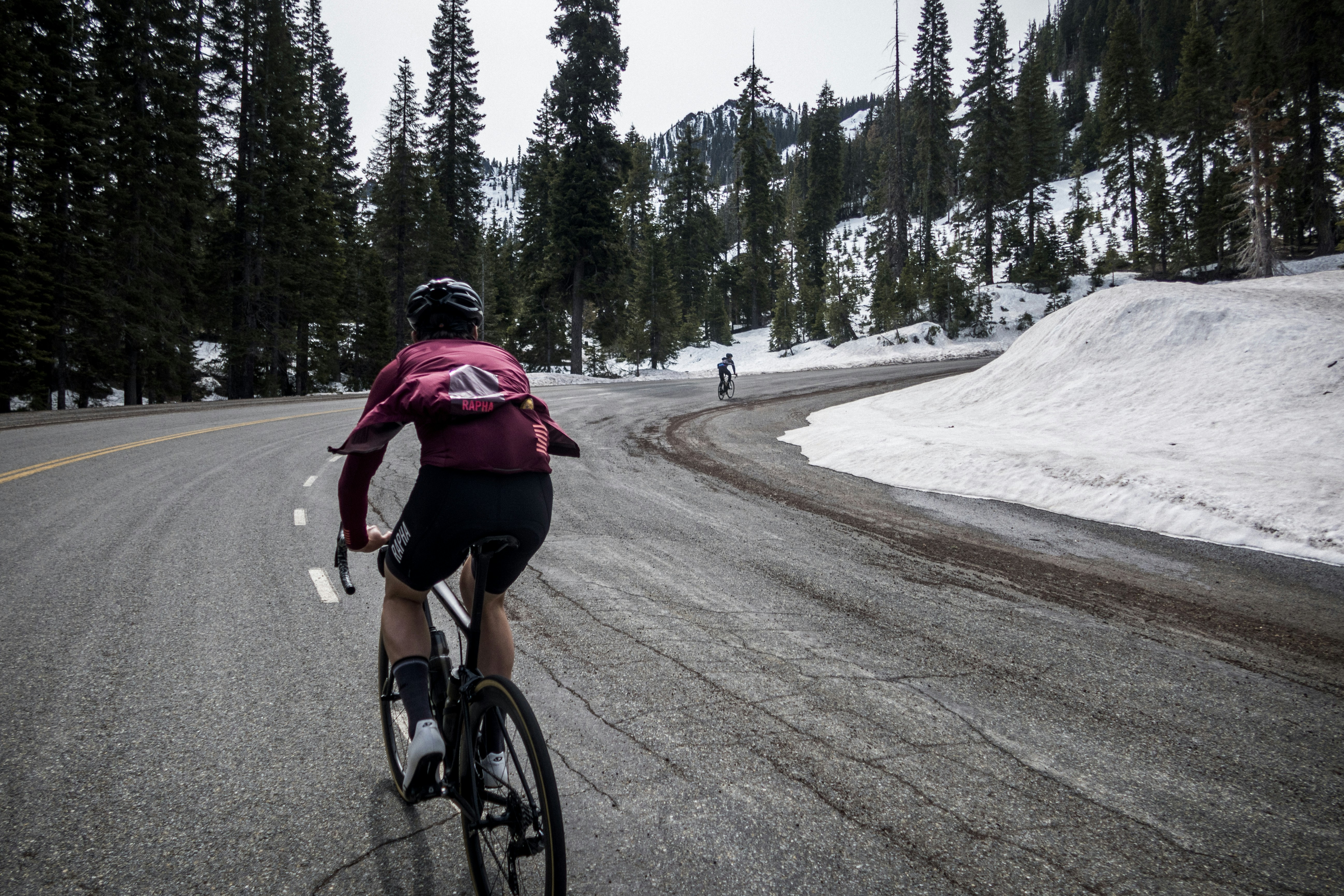 a man riding a bike down a snow covered road