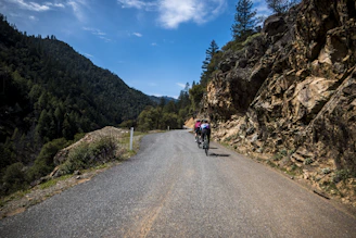 Cyclists riding together along a scenic mountain path during the Acambay pilgrimage.