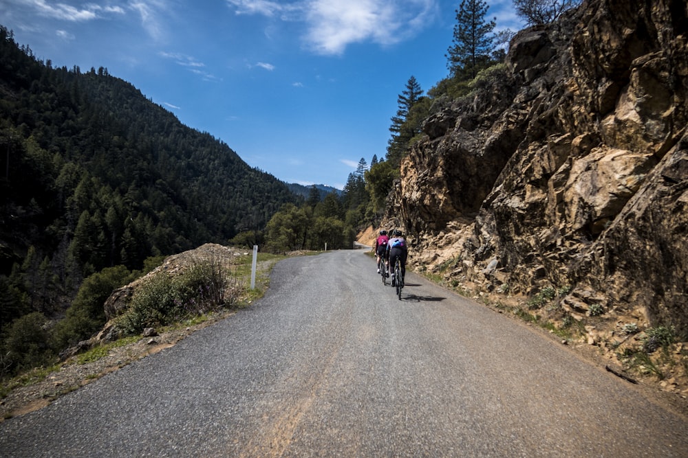 a couple of people riding bikes down a road