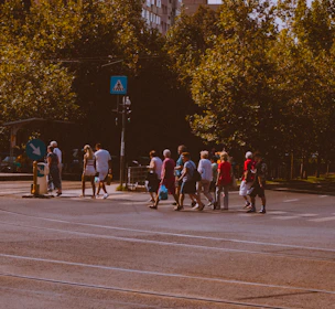 A cheerful team member helping an elderly person cross the street safely.