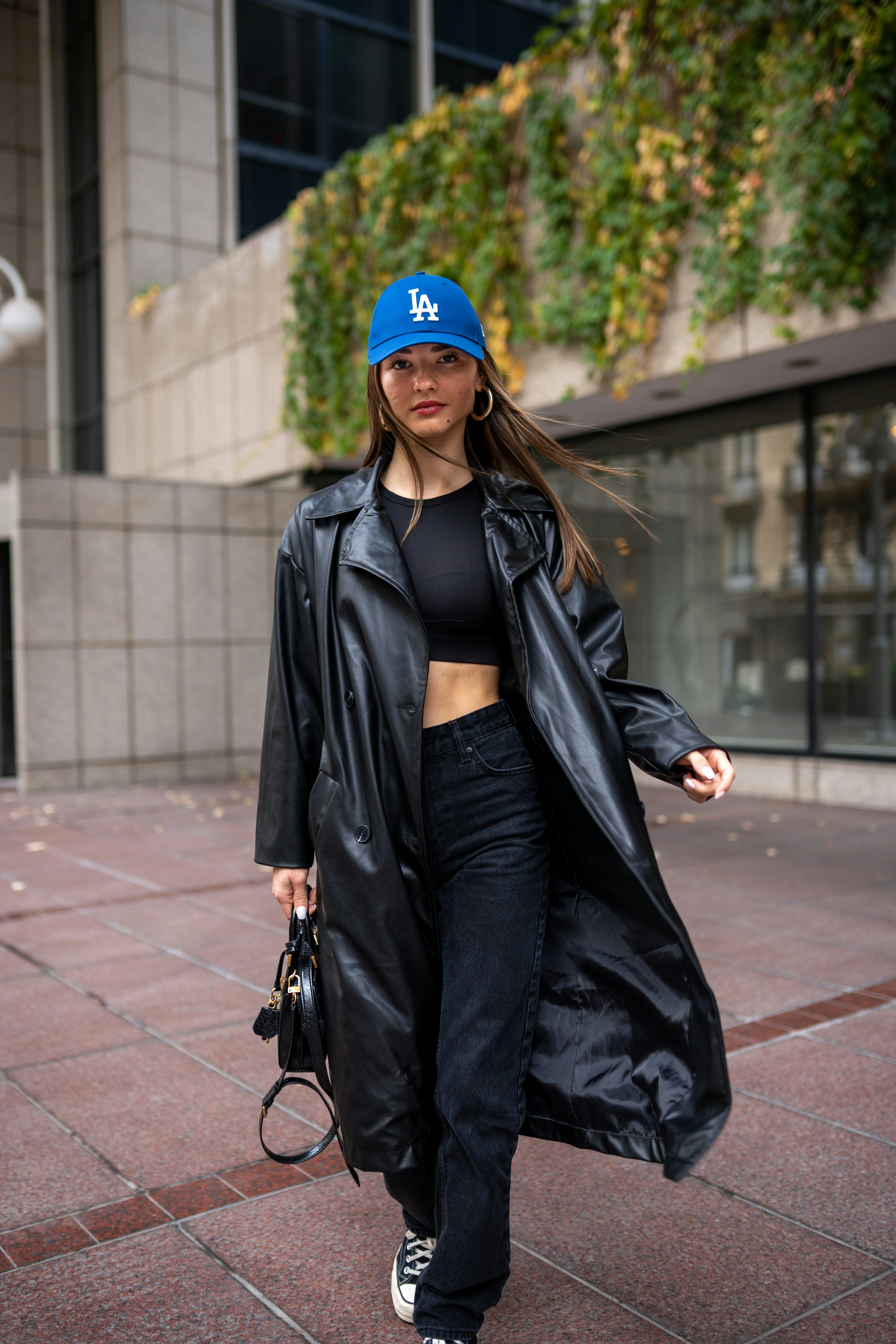 A woman walking down the street in a black coat photo – Free Portrait ...