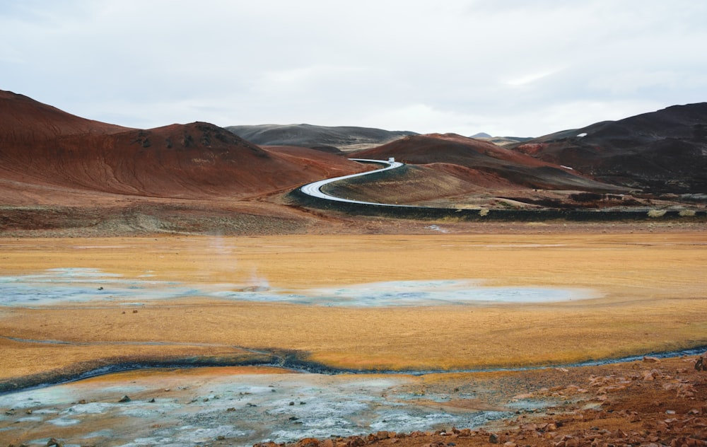 a wide open field with a river running through it