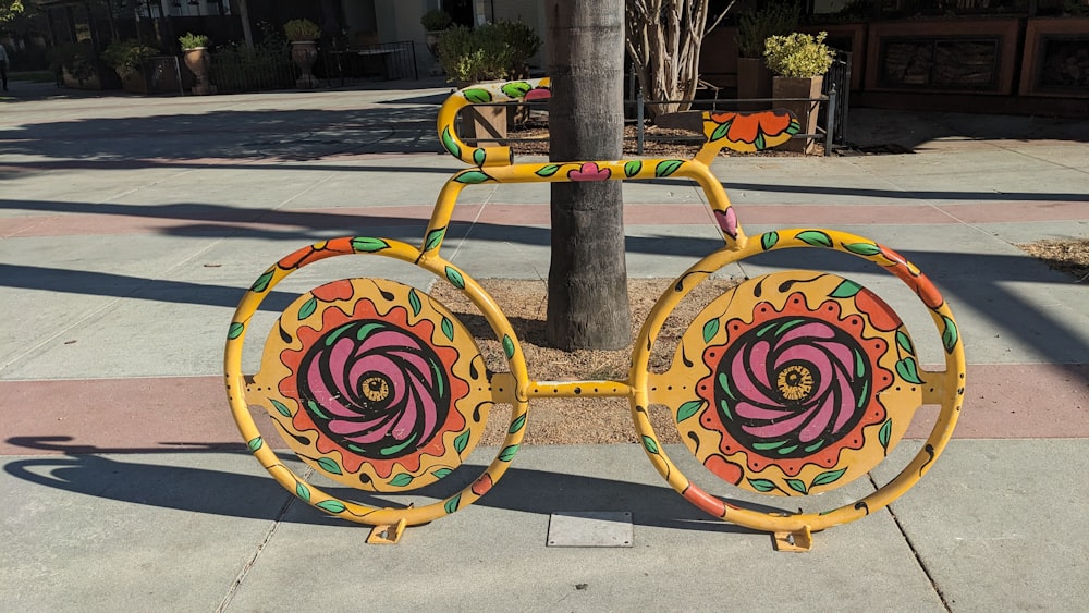 a yellow bicycle painted with a flower on the front