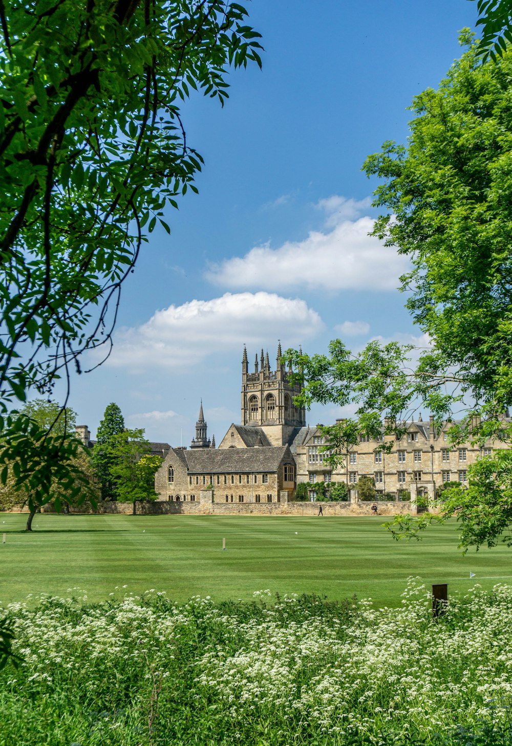 a large building with a clock tower in the middle of a field