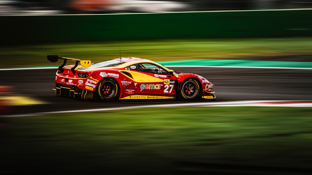 a red and yellow race car driving on a track