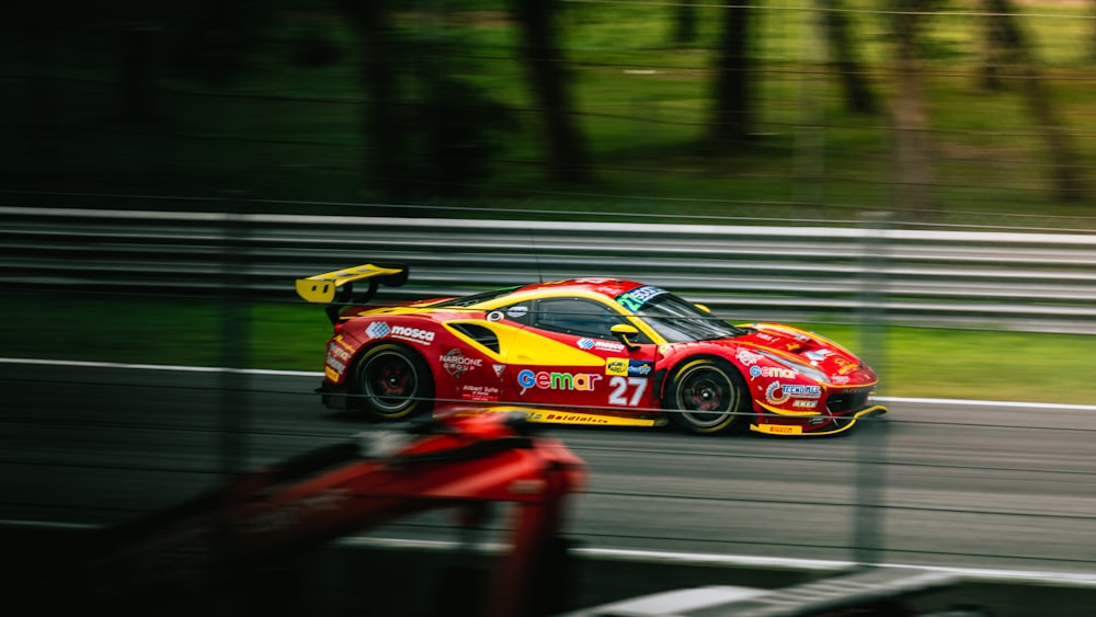 a red and yellow race car driving down a race track