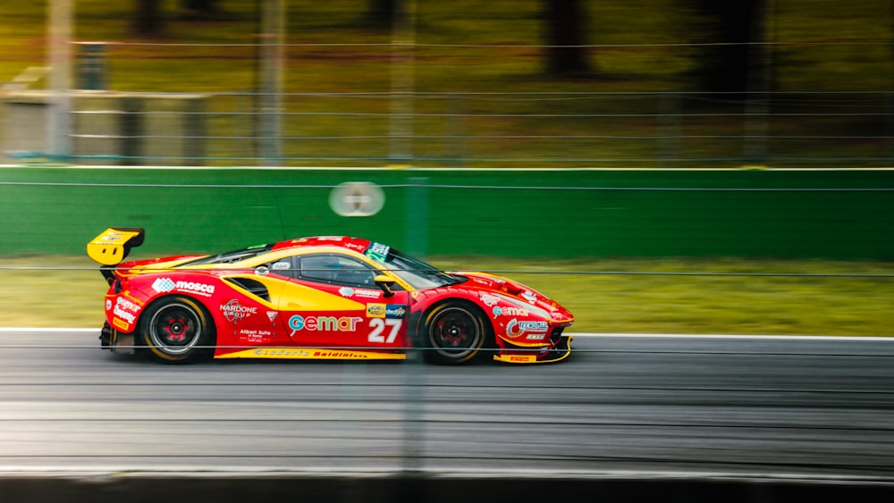 a red and yellow race car driving down a race track