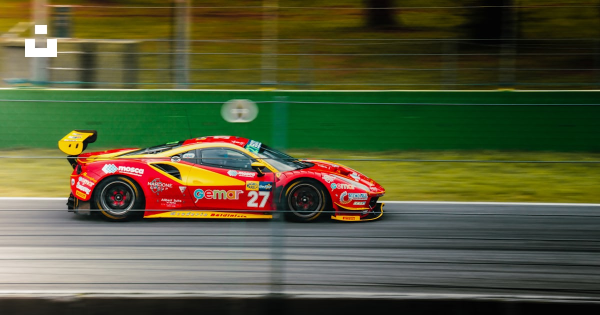 A red and yellow race car driving down a race track photo – Free Monza ...