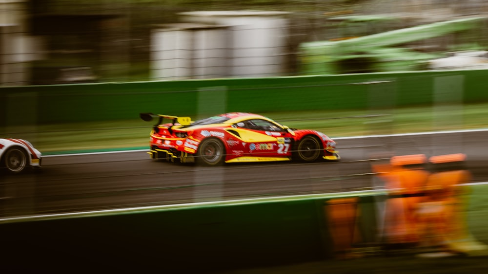 a red and yellow race car driving down a race track