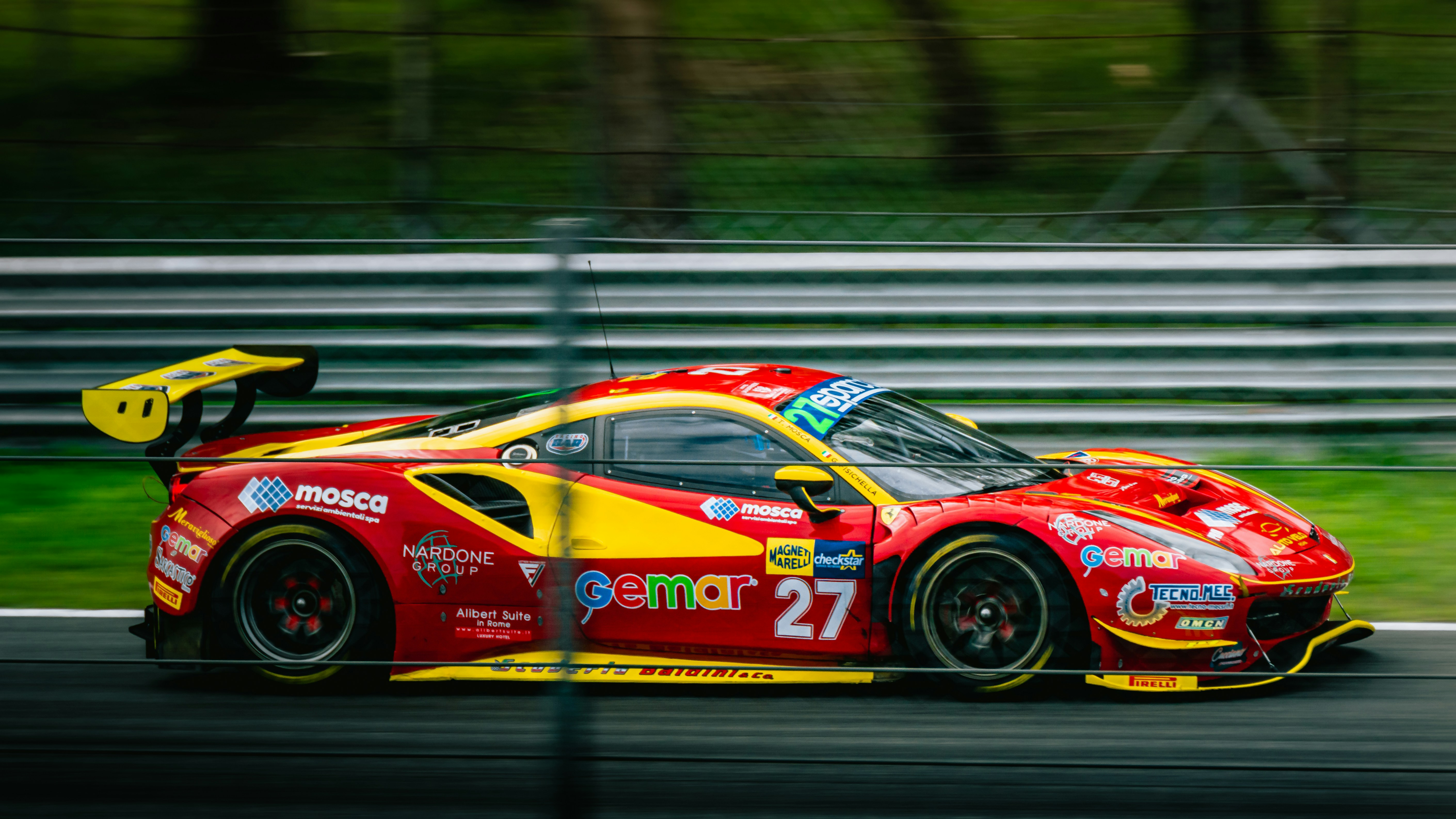 A red and yellow sports car driving on a race track photo Free Monza