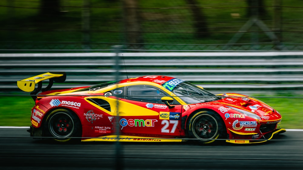 a red and yellow sports car driving on a race track