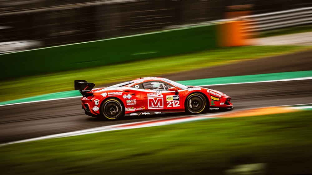 a red sports car driving down a race track