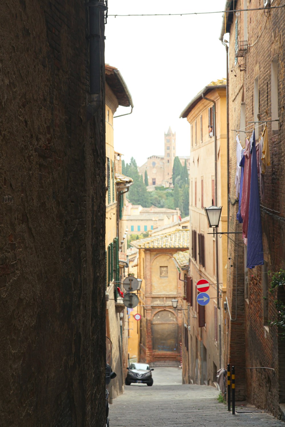 a narrow alley way with a car parked on the side