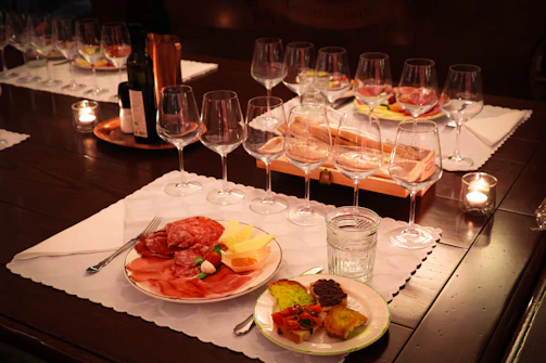 A warmly lit rustic table set with wine glasses and empanadas, inviting guests to a traditional Salta evening.