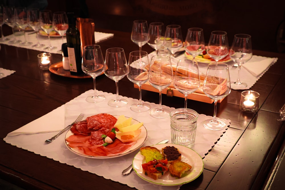 a table topped with plates of food and wine glasses