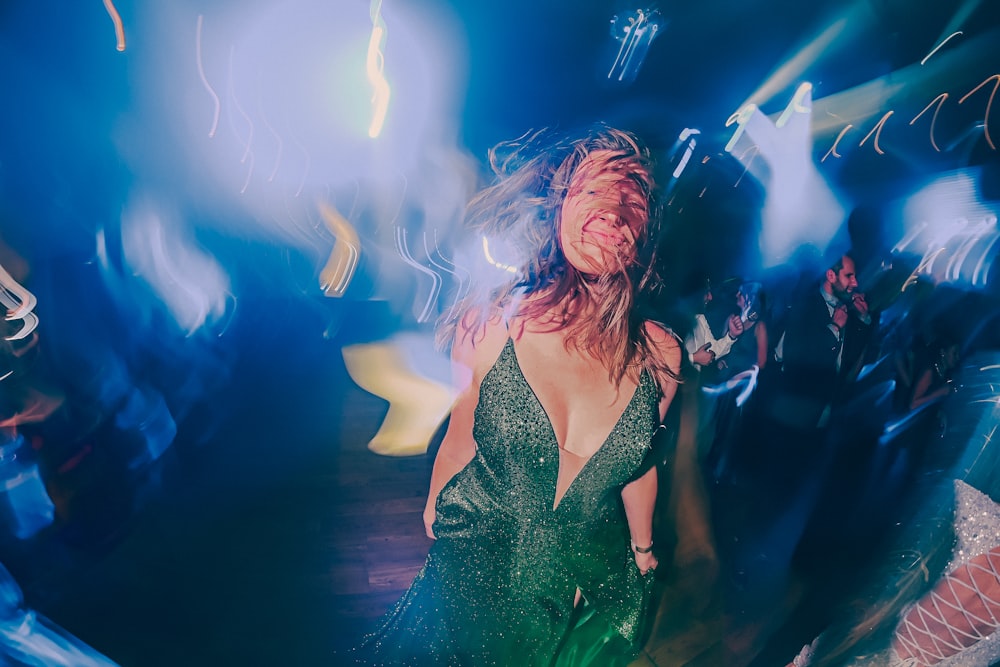 a woman in a green dress dancing at a party