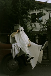 a man dressed as a ghost riding on the back of a truck