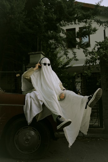 a man dressed as a ghost riding on the back of a truck