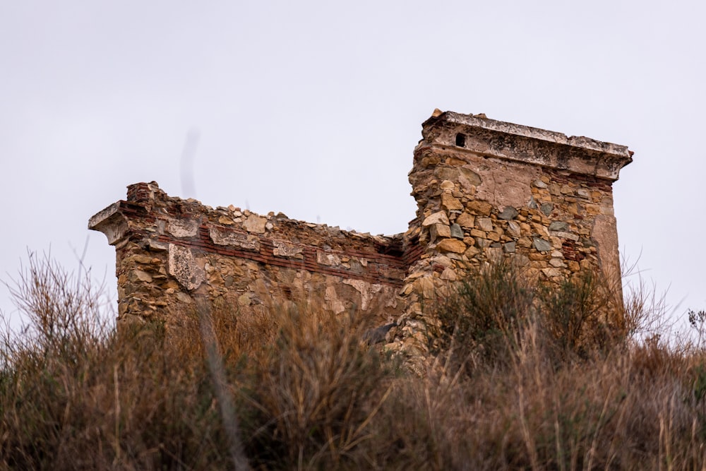 an old stone building sitting on top of a hill