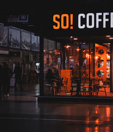 Evening view of customers enjoying coffee in a cozy, dimly lit cafe space.