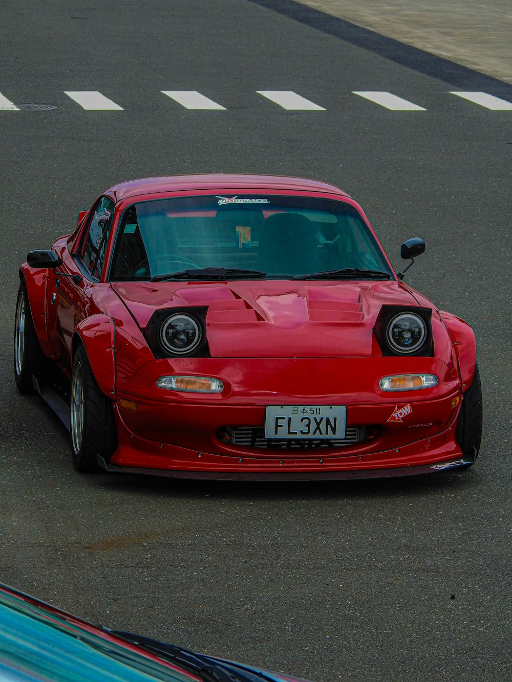 a red sports car driving down a street