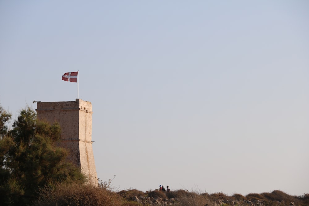 a tall tower with a flag on top of it