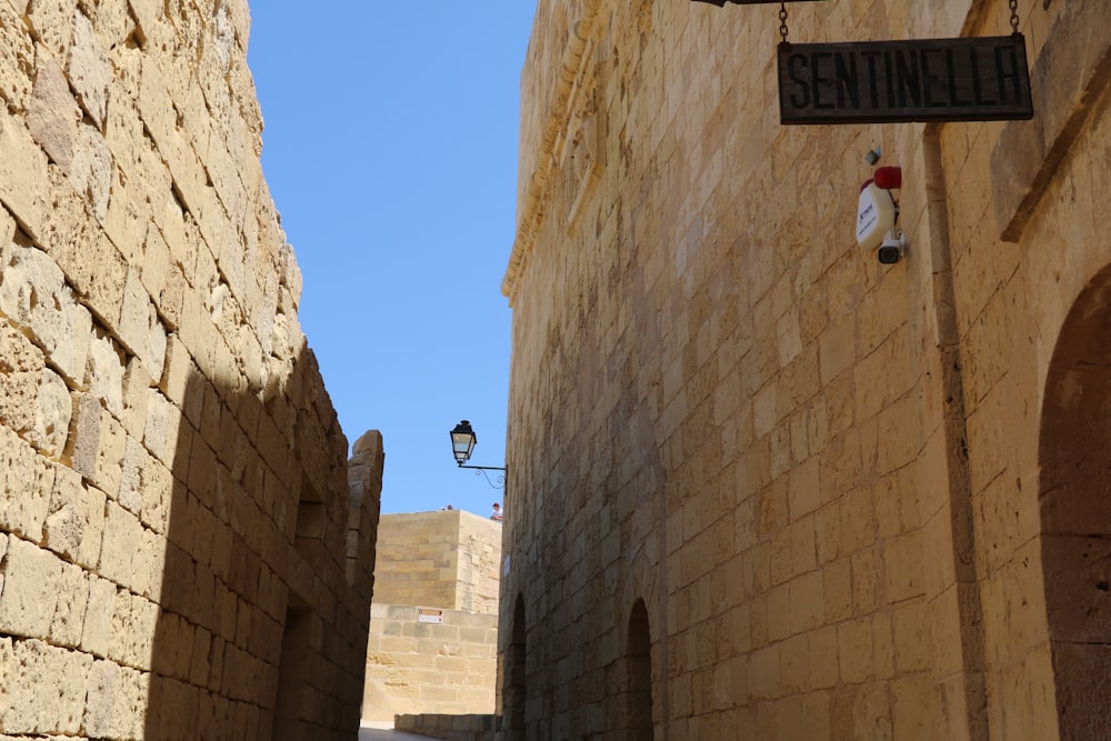 a narrow alley way with a street sign on it