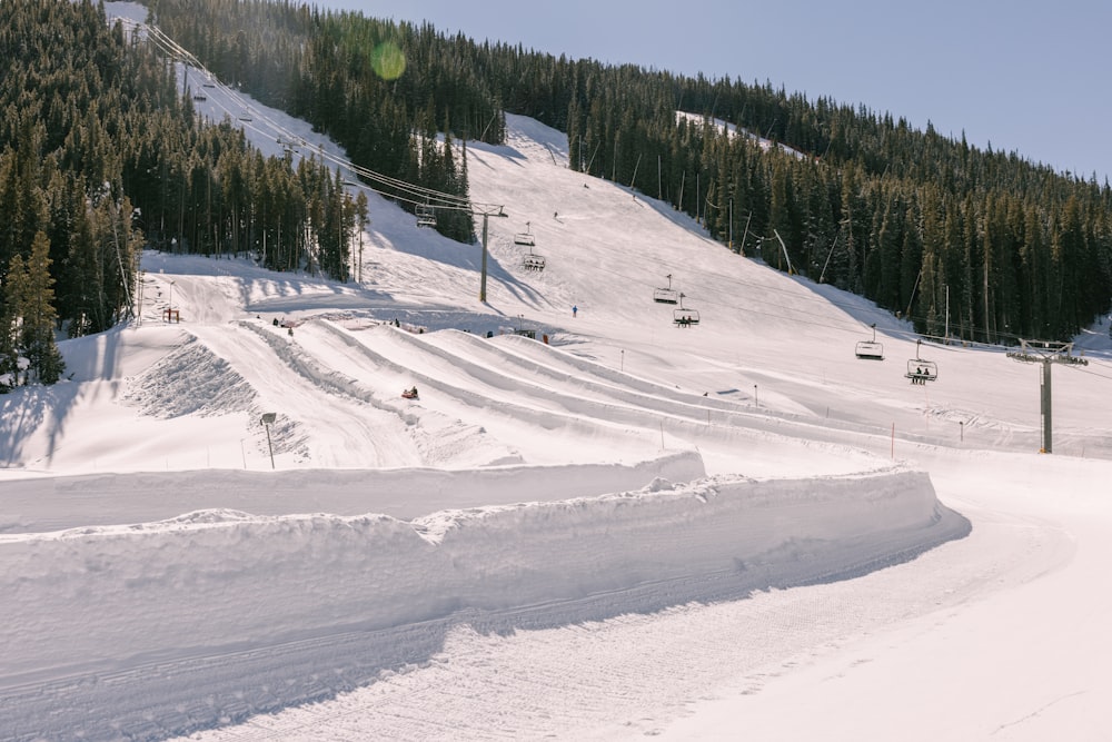 a snow covered ski slope with a ski lift in the background