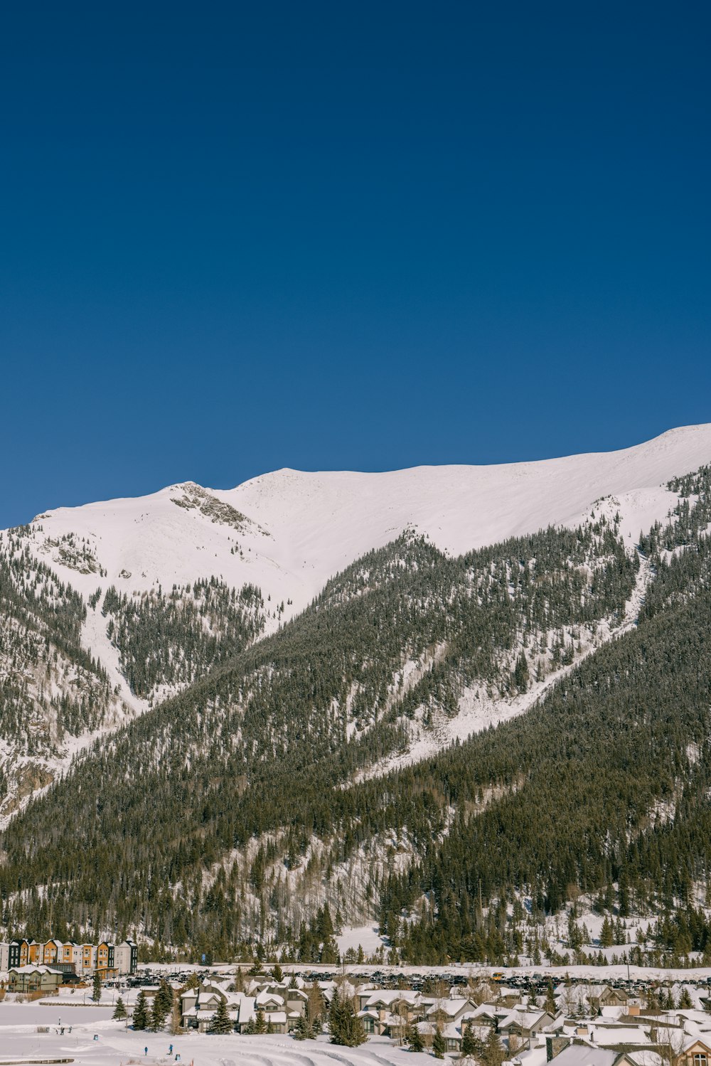 a snow covered mountain with a town in the foreground