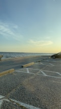 A serene beach view with a car parked nearby.