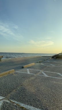 A serene beach view with a car parked nearby.