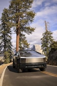 A futuristic electric vehicle driving on a scenic road.