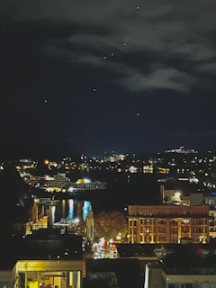 A cinematic night scene with glowing city lights reflecting off a river in Kyiv.