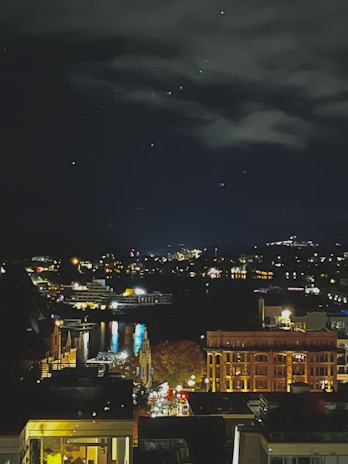 A cinematic night scene with glowing city lights reflecting off a river in Kyiv.