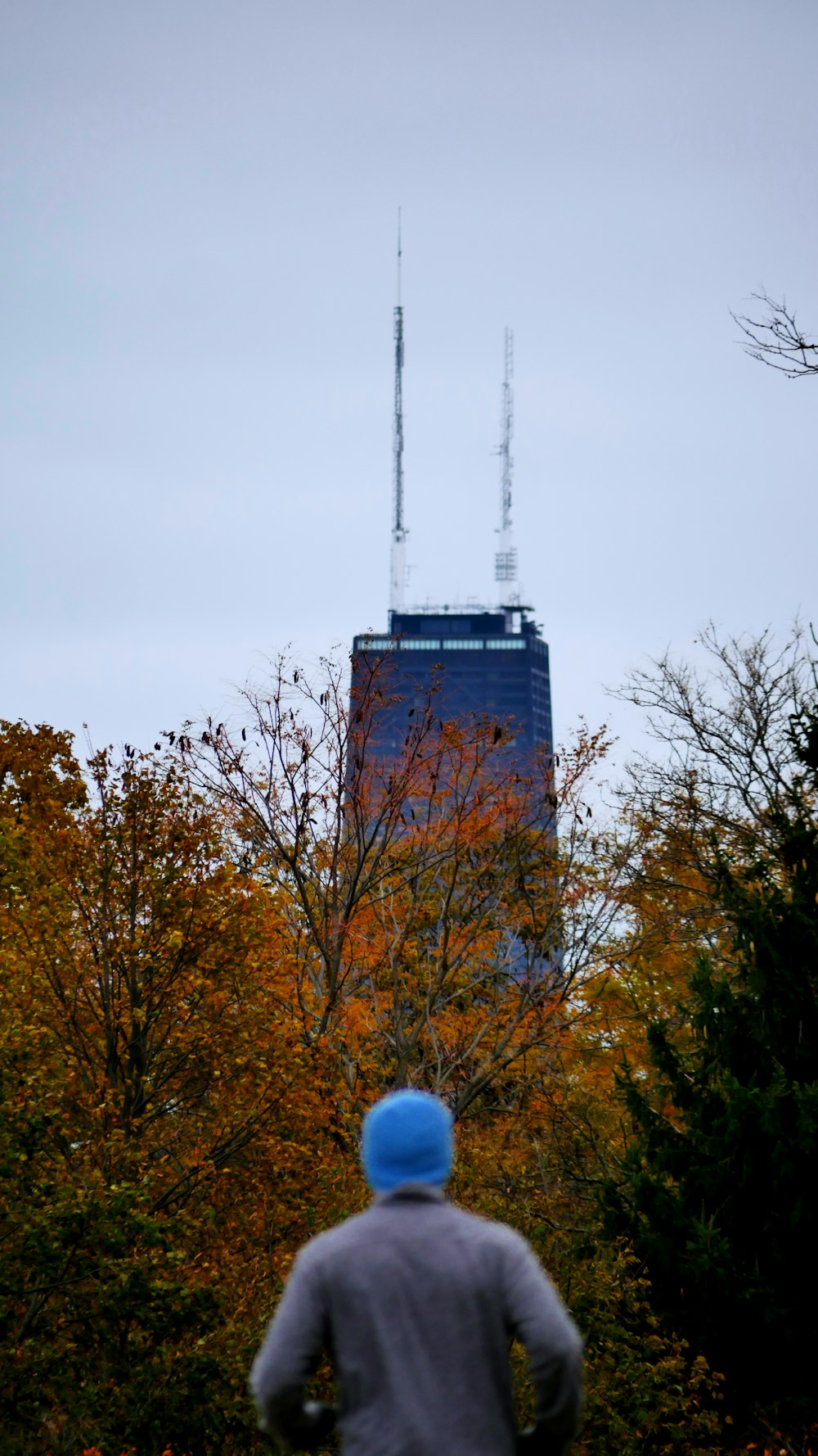 a man in a blue hat is looking at a tall building