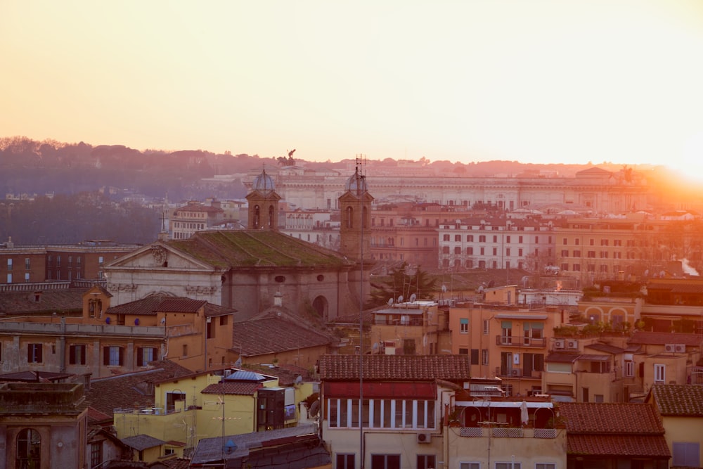 the sun is setting over a city with tall buildings