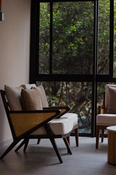 Cozy living room corner featuring a handcrafted wooden chair and soft cushions.