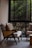 Cozy living room corner featuring a stylish armchair and decorative cushions near a window.