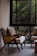 Cozy living room corner featuring a stylish armchair and decorative cushions near a window.