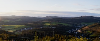 A panoramic view of Varde village with lush green fields and traditional houses under a clear blue sky.