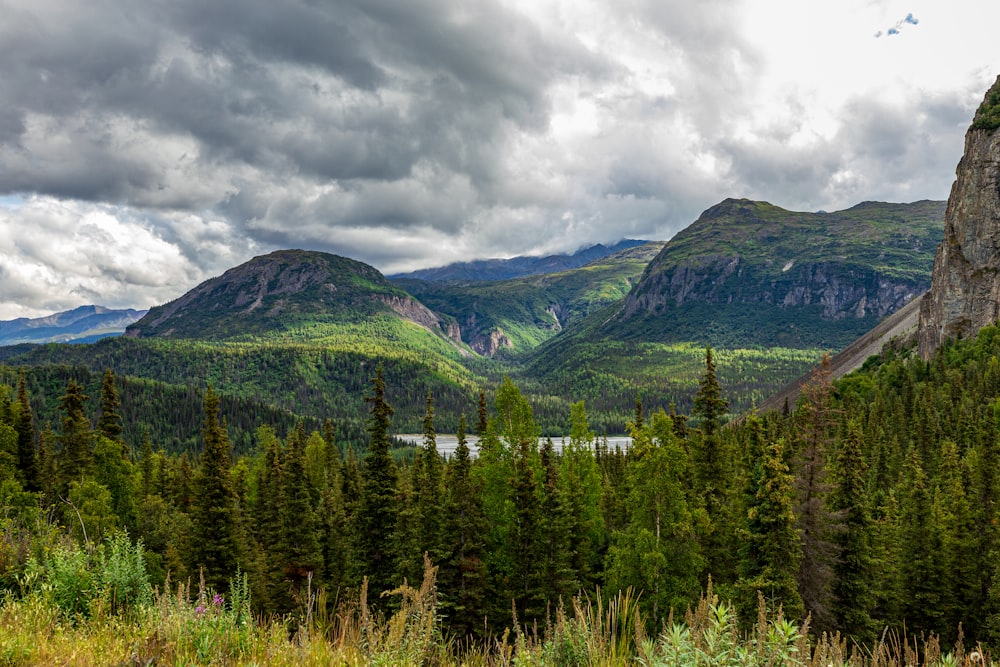 a scenic view of a mountain range with a lake in the foreground