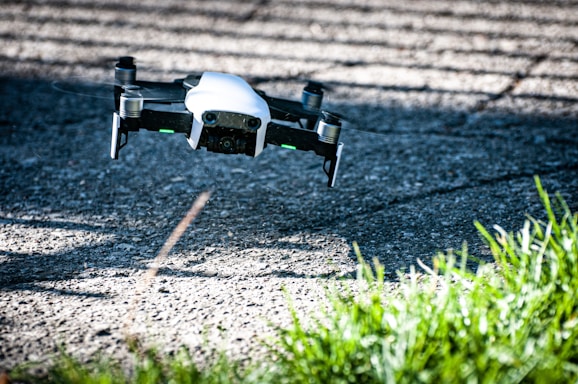 A drone flying near a building facade during a cleaning operation on a sunny day.