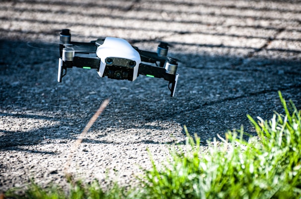 A drone flying above a green industrial area, capturing aerial footage.