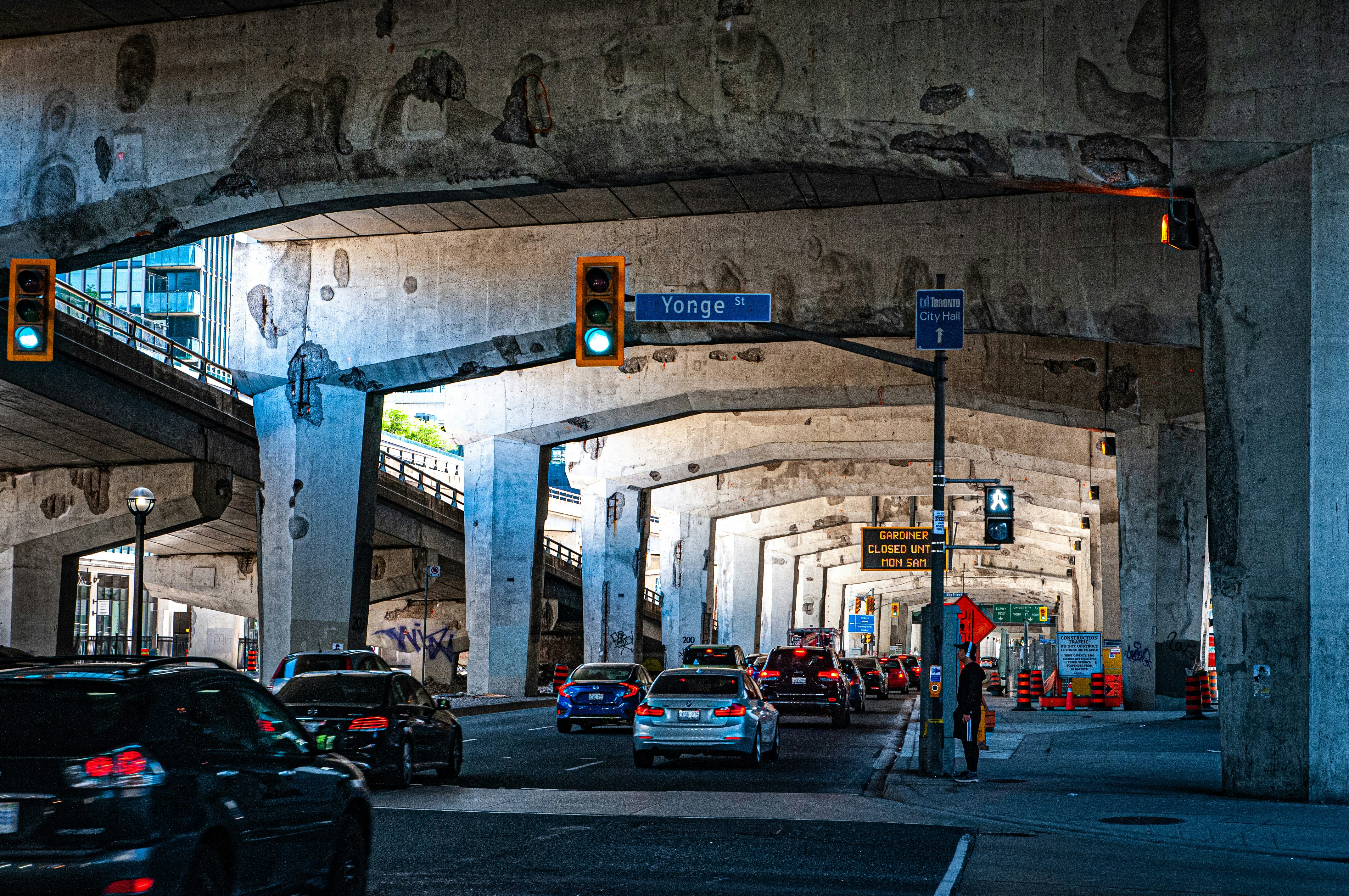 a street filled with lots of traffic under a bridge