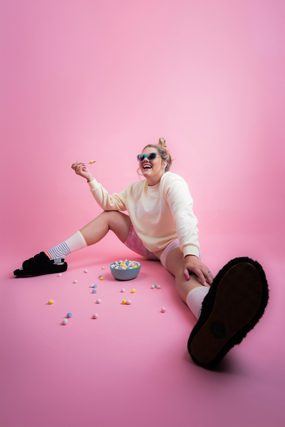 a woman sitting on the ground with a bowl of cereal