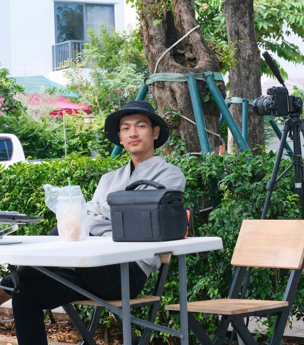 a man sitting at a table in front of a camera