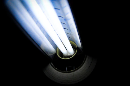 Close-up of green hydrogen fuel cells glowing with neon blue light.