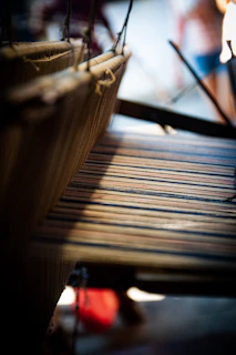 A wide shot of a loom with a hand-woven rug in progress, threads neatly aligned.