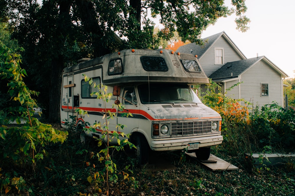 an old camper parked in front of a house